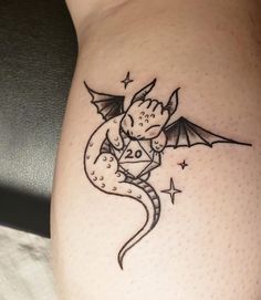 a small dragon tattoo on the side of a woman's thigh, with stars around it