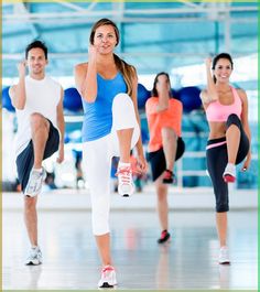 a group of people in a gym doing exercises with their hands up to their ears