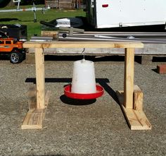 a red and white bucket sitting on top of a wooden table next to a truck