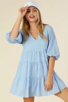 Gingham checked tiered dress- Description: This adorable dress features a yarn-dyed gingham check pattern, perfect for a playful and quirky look. With a flattering V-neck and cute puff sleeves, this dress is sure to turn heads. The 3/4 sleeve length and no stretch provide comfort, while the lining ensures there is no see-through. Model is 5'75" wearing size small Fabric Contents: 50% polyester 50% rayon Care instruction : hand wash cold, only non-chlorine bleach when needed, dry flat, cool iron