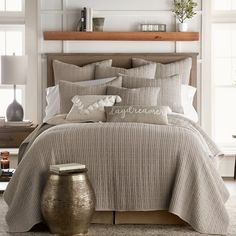 a bed in a bedroom with pillows and blankets on top of the bedspread