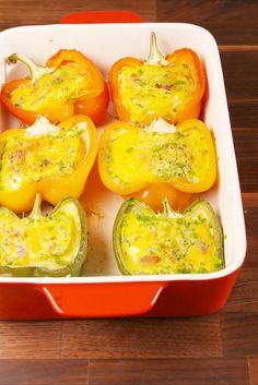 several peppers in a red casserole dish on a wooden table