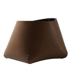 a brown leather lamp shade with holes in the middle on an isolated white background,