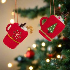 two red teapot ornaments hanging from a christmas tree