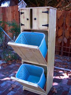 a wooden cabinet with two blue plastic baskets on the bottom and one in the middle