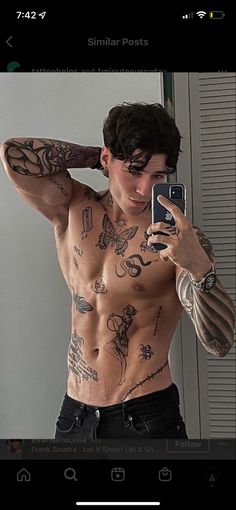 a man with tattoos taking a selfie in front of a mirror while holding a cell phone