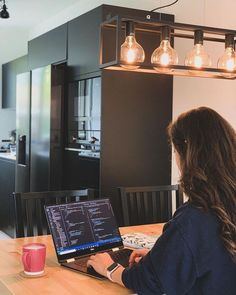 a woman sitting at a table using a laptop computer