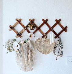 there are three baskets hanging on the wall with candles and flowers in them, along with other decorations