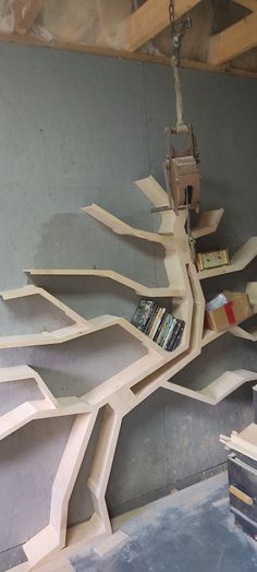 a wooden shelf with books on it in the middle of a room that is being built