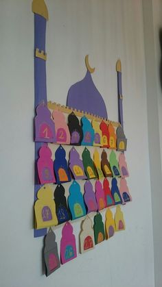 colorful paper cutouts are hanging on the wall