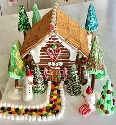 a gingerbread house is decorated with candy and christmas decorations on a table in the kitchen