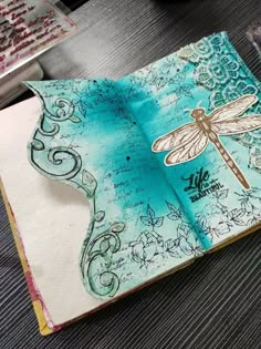 an open book with a dragonfly on it