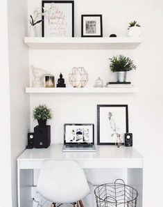 a white desk topped with a laptop computer next to shelves filled with pictures and plants