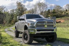 a large gray truck parked on top of a dirt road