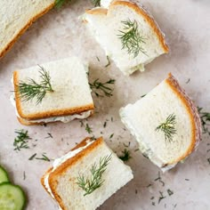 several pieces of bread with cucumber and dill on them next to some slices of bread