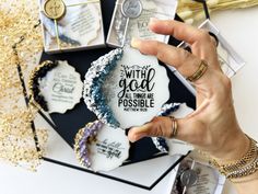 a woman holding up a white ornament that says with god we are possible