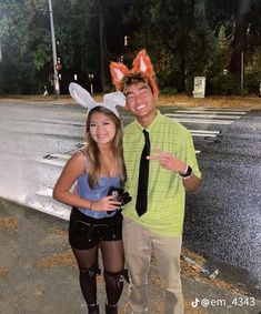 a man and woman dressed up in bunny ears posing for a photo on the street