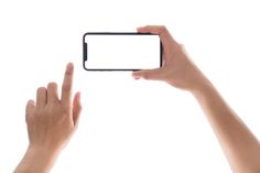 two hands holding up a cell phone with a blank screen in front of the camera