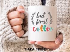 a woman holding a coffee mug with the words but first, cooker on it