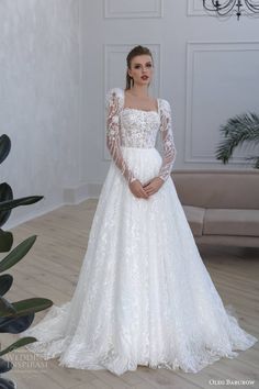 a woman in a white wedding dress standing on a wooden floor next to a plant