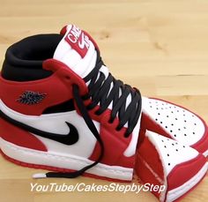 a pair of red and white sneakers on top of a wooden floor