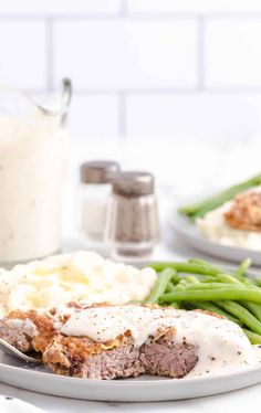 meatloaf with mashed potatoes, green beans and gravy on a plate