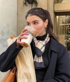 a woman is drinking from a coffee cup