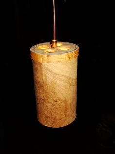 a candle holder made out of wood and glass with a light on it's side