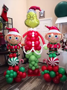 three inflatable christmas balloons with elfs and candy canes on the floor