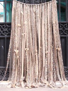 an old curtain is hanging on the side of a building in front of a gate