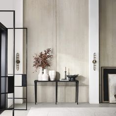 a table with two vases on it next to a fire place in a room