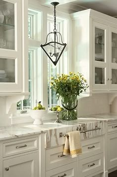 an image of a kitchen with white cabinets and marble counter tops on the website page