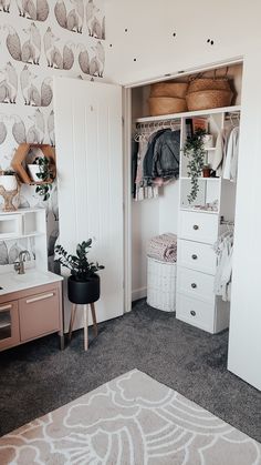 a white closet filled with clothes next to a wallpapered wall and flooring