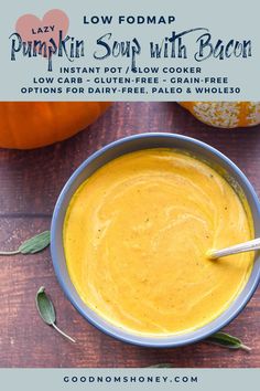 pumpkin soup with bacon in a bowl on a wooden table next to an orange pumpkin