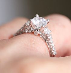 a close up of a person's hand holding a diamond ring