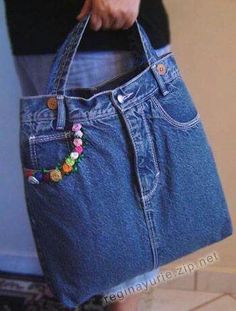 a person holding a blue jean purse with beads on it