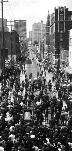 an old black and white photo of people on the street