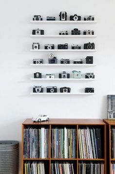 the wall is filled with shelves full of movies and video tape recorders, as well as various records