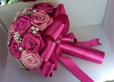 a bridal bouquet with pink roses and pearls on the top is sitting in a box