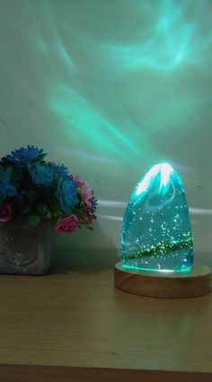 a vase with flowers on a table next to a glass dome shaped like a mountain