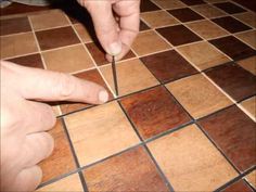 a person is cutting through some wood with scissors on the floor in front of them