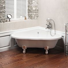 a bathroom with a claw foot bathtub and sink in the corner, along with two mirrors on the wall