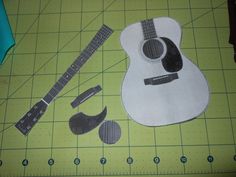 an acoustic guitar cut out on a cutting mat