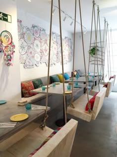 a living room filled with lots of furniture and hanging swings in the middle of it