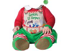 a baby dressed as santa clause sitting on the floor