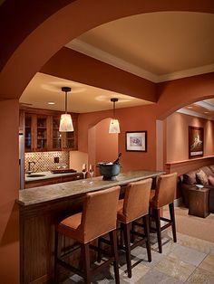 a living room filled with furniture next to a kitchen and dining room table in front of a bar