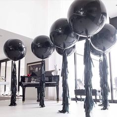 large black balloons are in the middle of a room