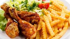 chicken wings, french fries and salad on a white plate