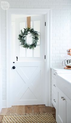 a white door with a wreath hanging on it