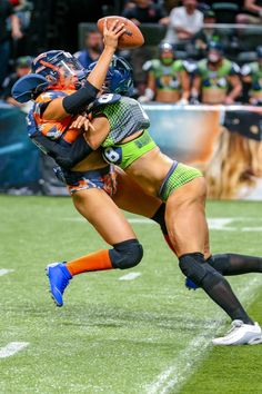 a female football player holding a ball in her right hand as she dives for it